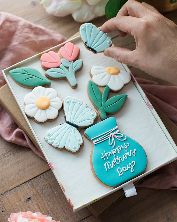 Honeywell Bakes Large Spring Biscuit Blooms - Decorative cookies shaped like flowers and a vase with 'Happy Mother's Day' text on a wooden surface.