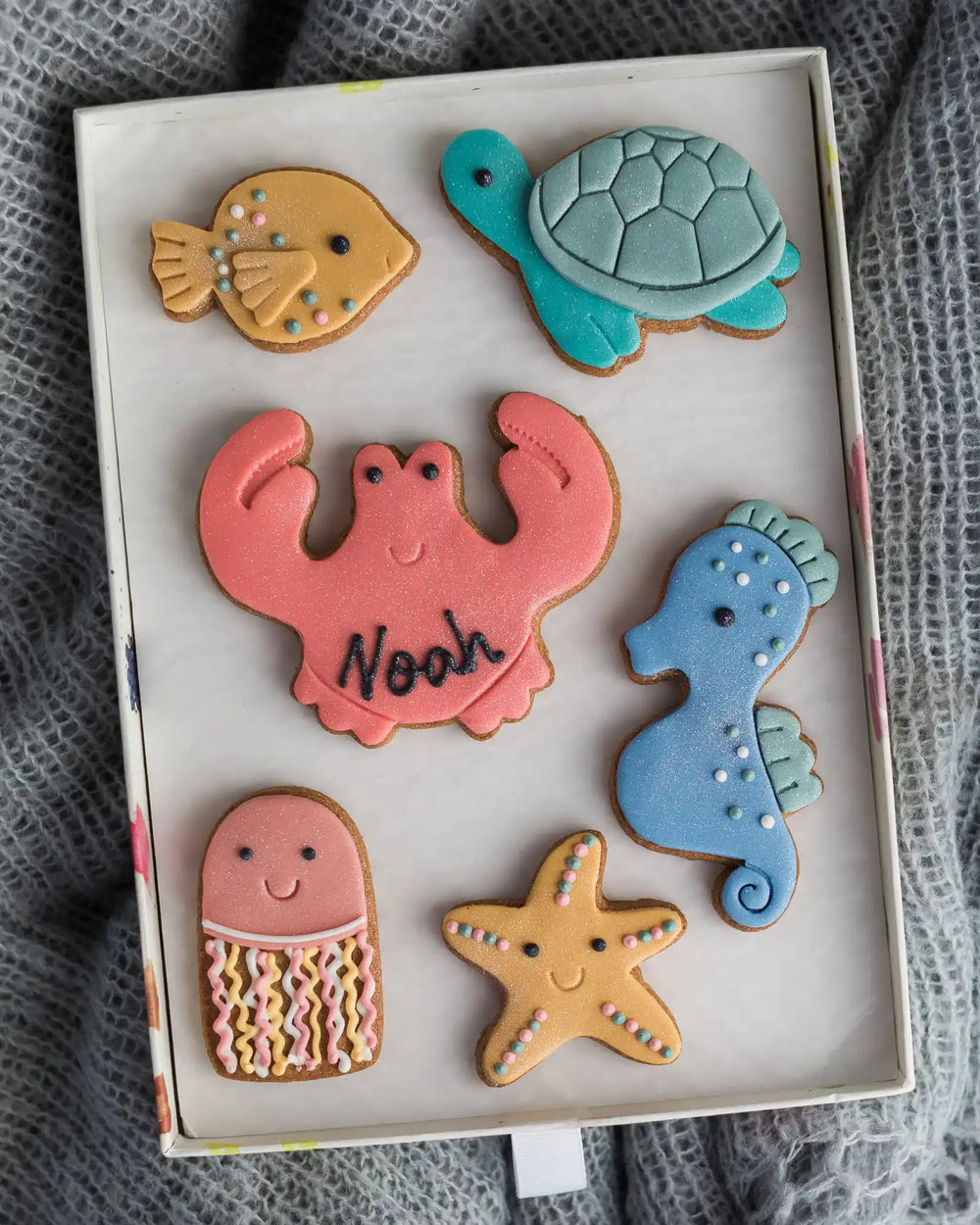 Honeywell Bakes Large Under The Sea Biscuit Gift - Colourful cookie cutouts shaped like a turtle, crab, shell, and starfish on a plate.