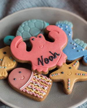Honeywell Bakes Large Under The Sea Biscuit Gift - Colourful cookie cutouts shaped like a turtle, crab, shell, and starfish on a plate.