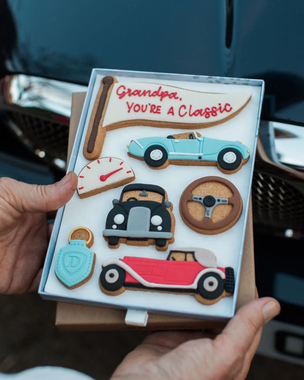 Honeywell Bakes Large You’re A Classic Biscuit Gift - Cookie set with vintage car designs and 'Grandpa, You're a Classic' message in front of a car.