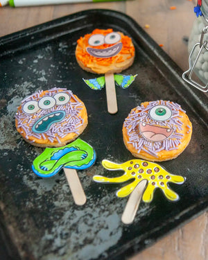 Honeywell Bakes Monster Biscuit Pop Baking Kit - Colourful monster-themed cookies on sticks on a baking tray.