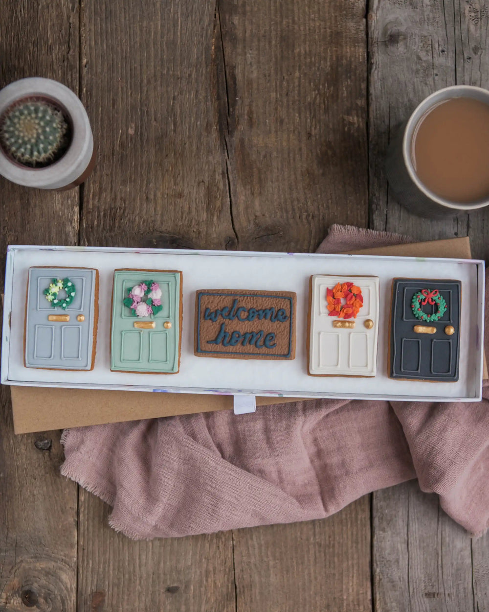 Honeywell Bakes New Home Biscuit Gift Set - Decorative cookies shaped like doors with different designs on a wooden surface.