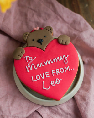 Honeywell Bakes Personalised Bear Hug Biscuit - large biscuit bear holding a heart with ’To Mummy, Love from Leo’ text.