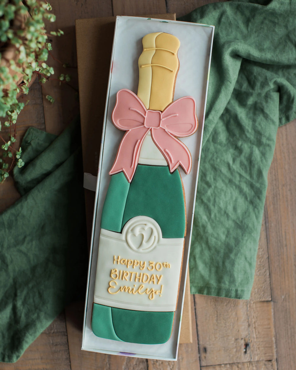 Honeywell Bakes Personalised Champagne Biscuit Bottle - Green - Large celebration champagne bottle biscuit personalised next to a real sized champagne bottle