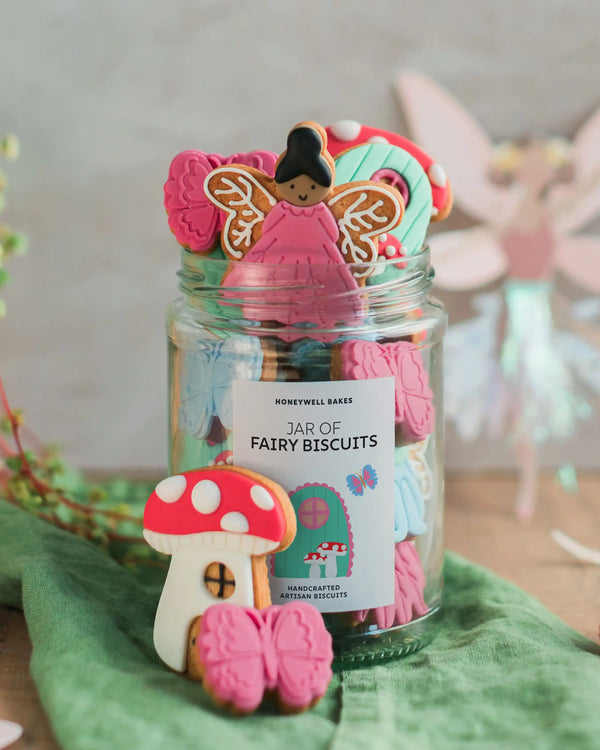 Honeywell Bakes Personalised Fairy Garden Biscuit Jar - Jar of fairy-themed cookies with a decorative label on a green surface.