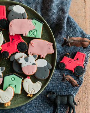 Honeywell Bakes Personalised Jar of Farm Animal Biscuits - Farm-themed cookies on a plate with small figurines on a textured surface
