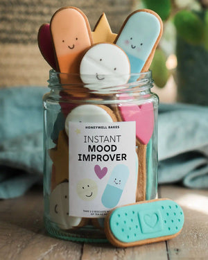 Close-up of a personalised label on a jar of colourful biscuit pills, with a custom message for a thoughtful and playful gift.
