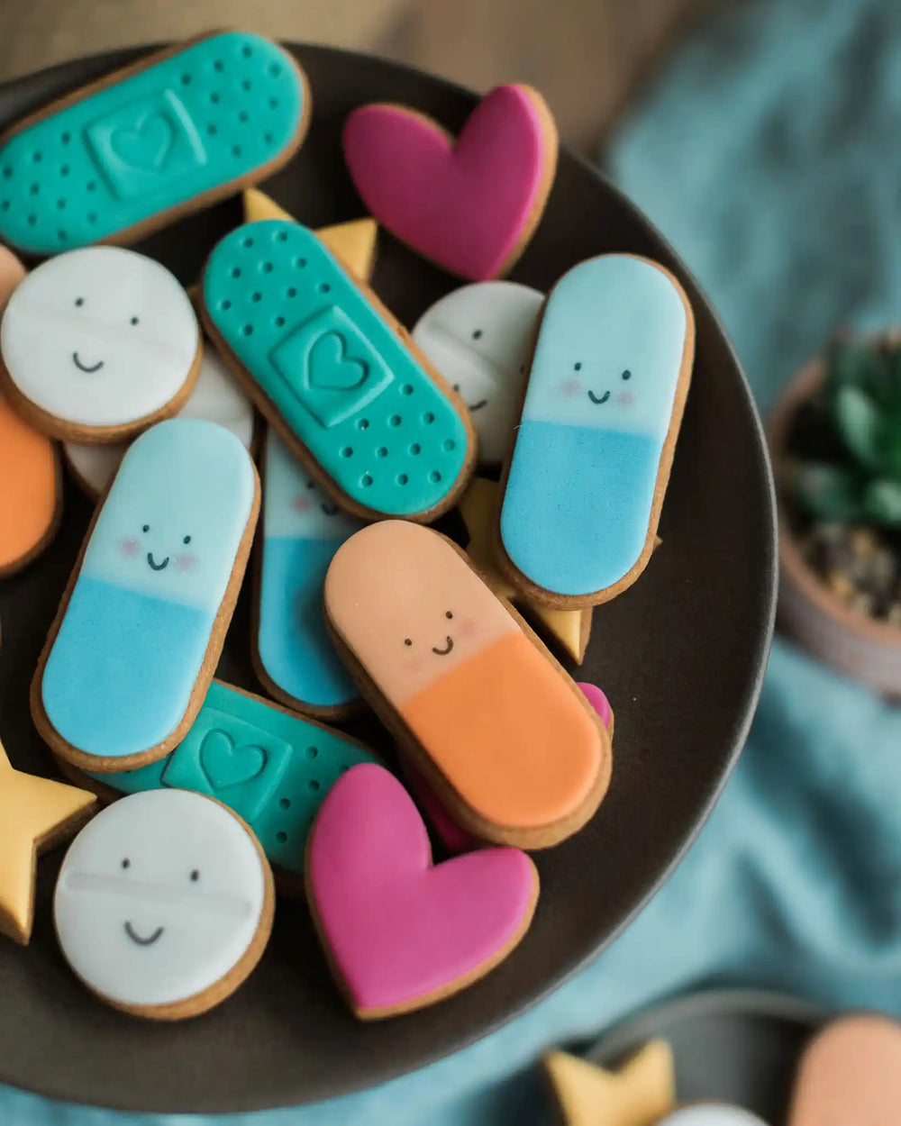 Personalised jar of colourful biscuit pills from Honeywell Bakes, decorated with smiley faces, hearts, plasters and stars, a fun feel-good gift.