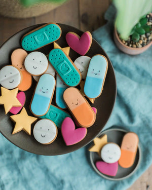 Close-up of a personalised label on a jar of colourful biscuit pills, with a custom message for a thoughtful and playful gift.