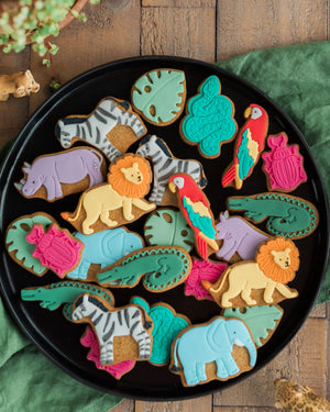 Honeywell Bakes Personalised Jar of Safari Biscuits - Assorted animal-shaped cookies on a black plate with a wooden background