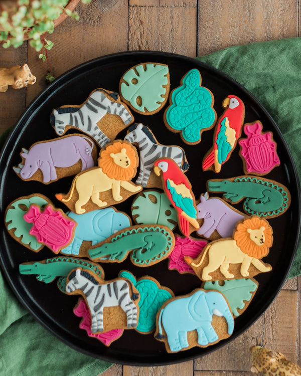 Honeywell Bakes Personalised Jar of Safari Biscuits - Assorted animal-shaped cookies on a black plate with a wooden background