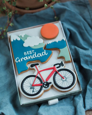 Honeywell Bakes Personalised Medium Bicycle Biscuit Gift - Biscuit set with bicycle design and 'Best Grandad' text on a blue fabric background