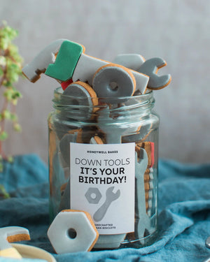 Honeywell Bakes Personalised Jar of Tools - Jar of cookie tools with a birthday message on a blue fabric background