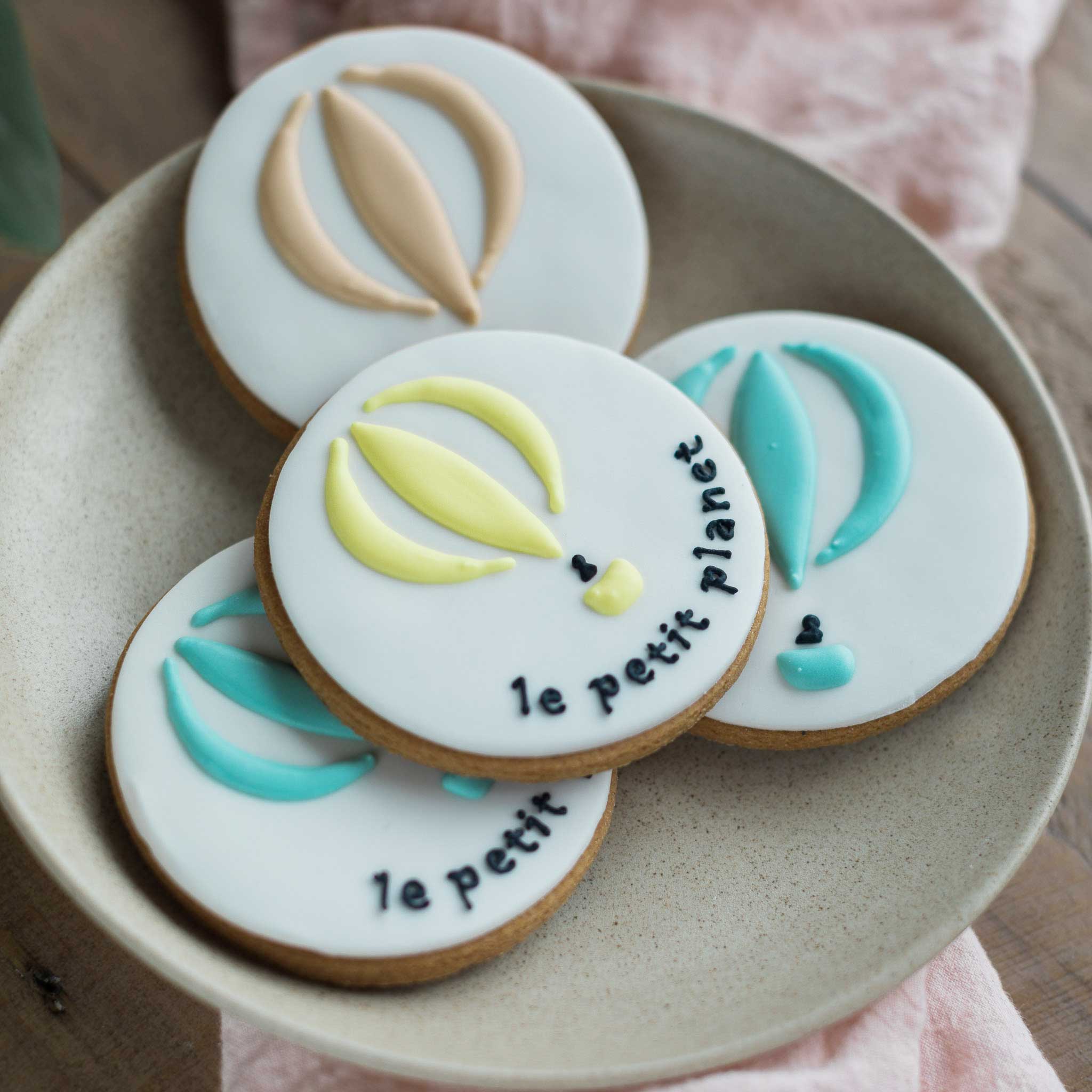 Hand iced custom branded logo biscuits with hot air balloon in pastel colours by Honeywell Bakes 