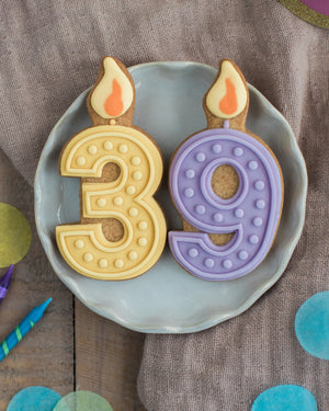 Honeywell Bakes Pick Your Own Milestone Birthday Biscuits - Two cookies shaped like candles with numbers '3' and '9' on a plate.