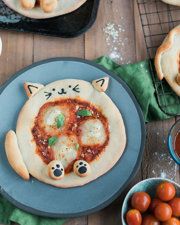 Honeywell Bakes Pizza Pet Baking Kit - Cat-shaped pizza on a blue plate with a wooden background