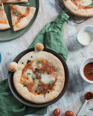 Honeywell Bakes Pizza Pet Baking Kit - 
Small pizza on a pan with ingredients around on a wooden surface