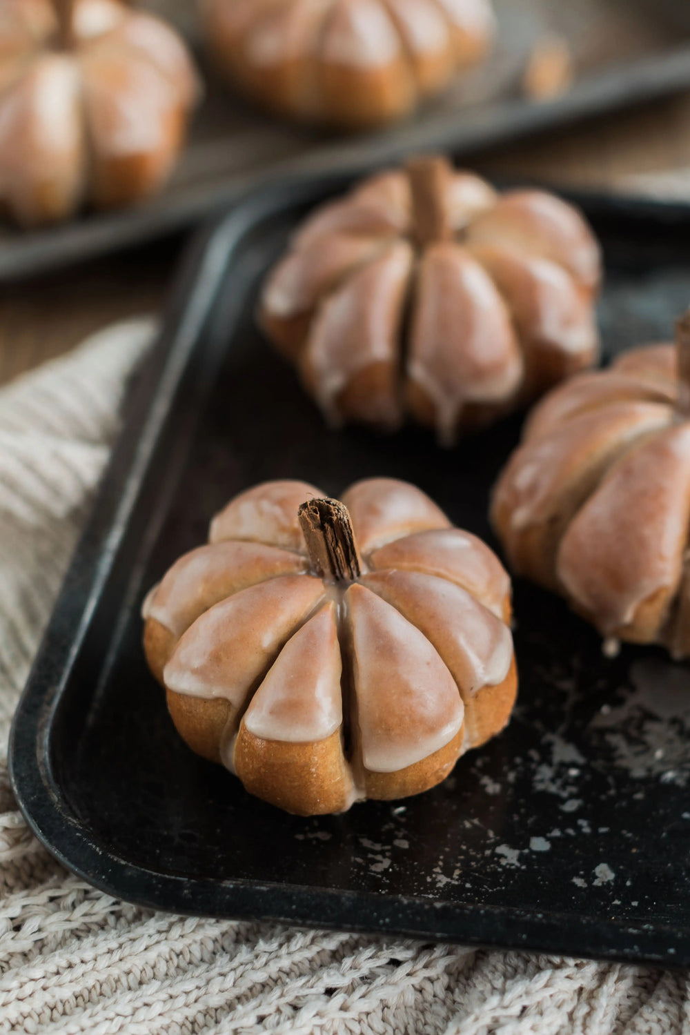 Honeywell Bakes Pumpkin Spiced Iced Bun Baking Kit - Decorative bread pumpkins on a dark tray with a soft focus background