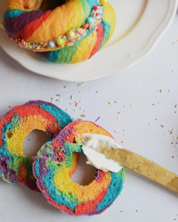 Honeywell Bakes Rainbow Bagel Bread Kit Colourful bagels sliced open on a plate with sprinkles