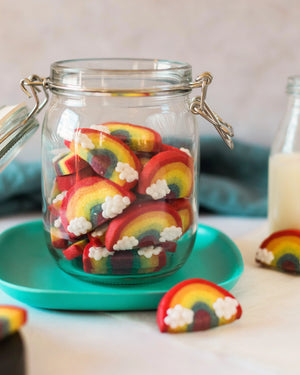 Honeywell Bakes Rainbow Biscuit Baking Kit - Glass jar filled with rainbow-shaped cookies on a teal plate with a blurred background