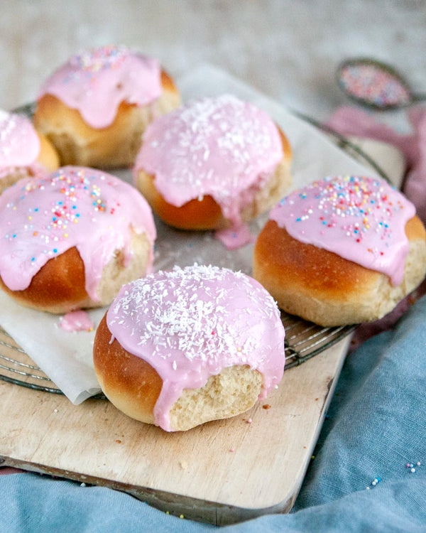 Honeywell Bakes Young Bakers Subscription, Six iced buns with pink icing, topped with shredded coconut and colourful sprinkles