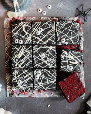 Honeywell Bakes Spooky Traybake Baking Kit - Halloween-themed brownies with spider webs, eyeballs, and a spider on a gray surface.