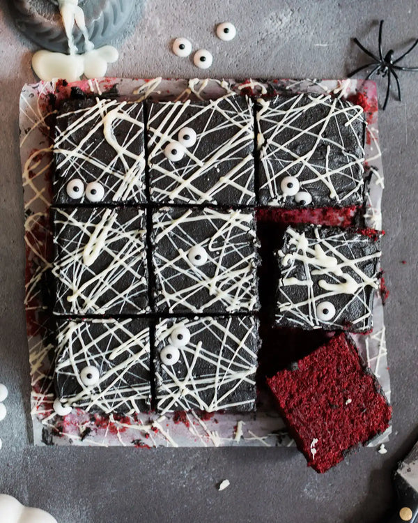 Honeywell Bakes Spooky Traybake Baking Kit - Halloween-themed brownies with spider webs, eyeballs, and a spider on a gray surface.