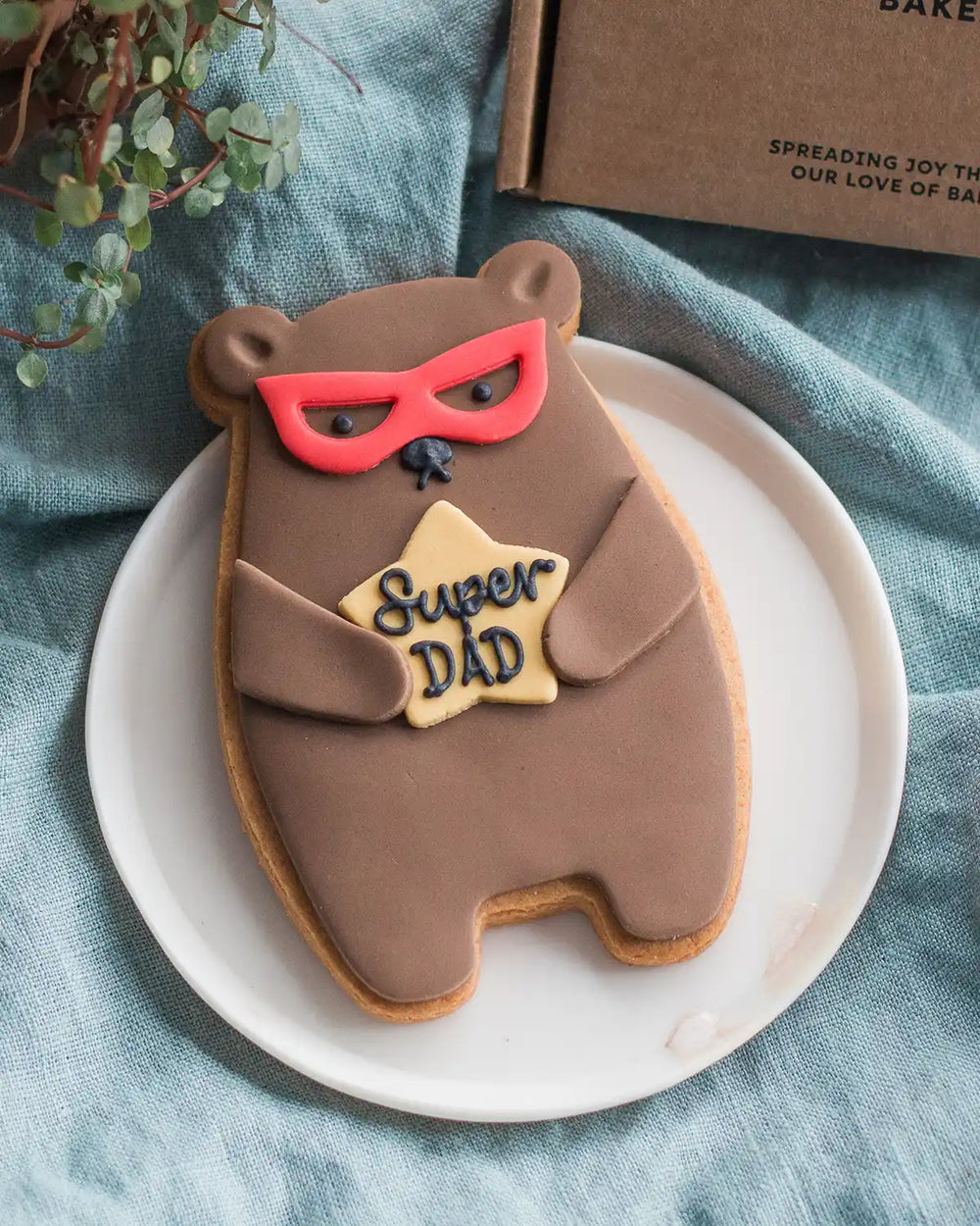 Honeywell Bakes Super Dad Bear Biscuit - Cookie shaped like a bear with a superhero mask and 'Super Dad' text on a white plate.