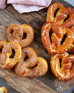 Honeywell Bakes Sweet or Savoury Heart Pretzel Baking Kit - Two types of pretzels on a wooden board, one with sugar coating and the other salt.