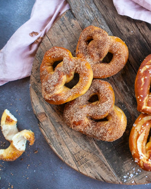 Honeywell Bakes Sweet or Savoury Heart Pretzel Baking Kit - Cinnamon-sugar pretzels on a wooden board with a pink cloth in the background