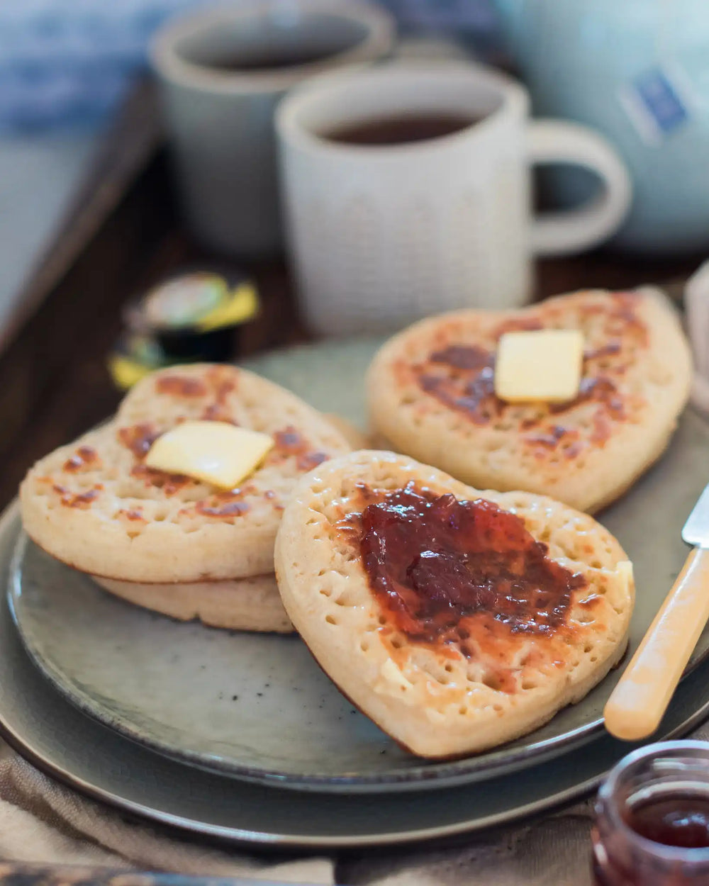 Honeywell Bakes Tea And Crumpets For Two Baking Kit - Heart-shaped crumpets with butter and jam on a plate with mugs of tea and a teapot.