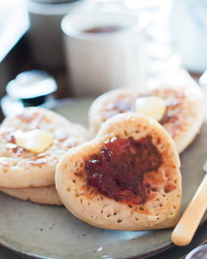Honeywell Bakes Tea And Crumpets For Two Baking Kit - Heart-shaped crumpets with strawberry jam and butter on a plate.