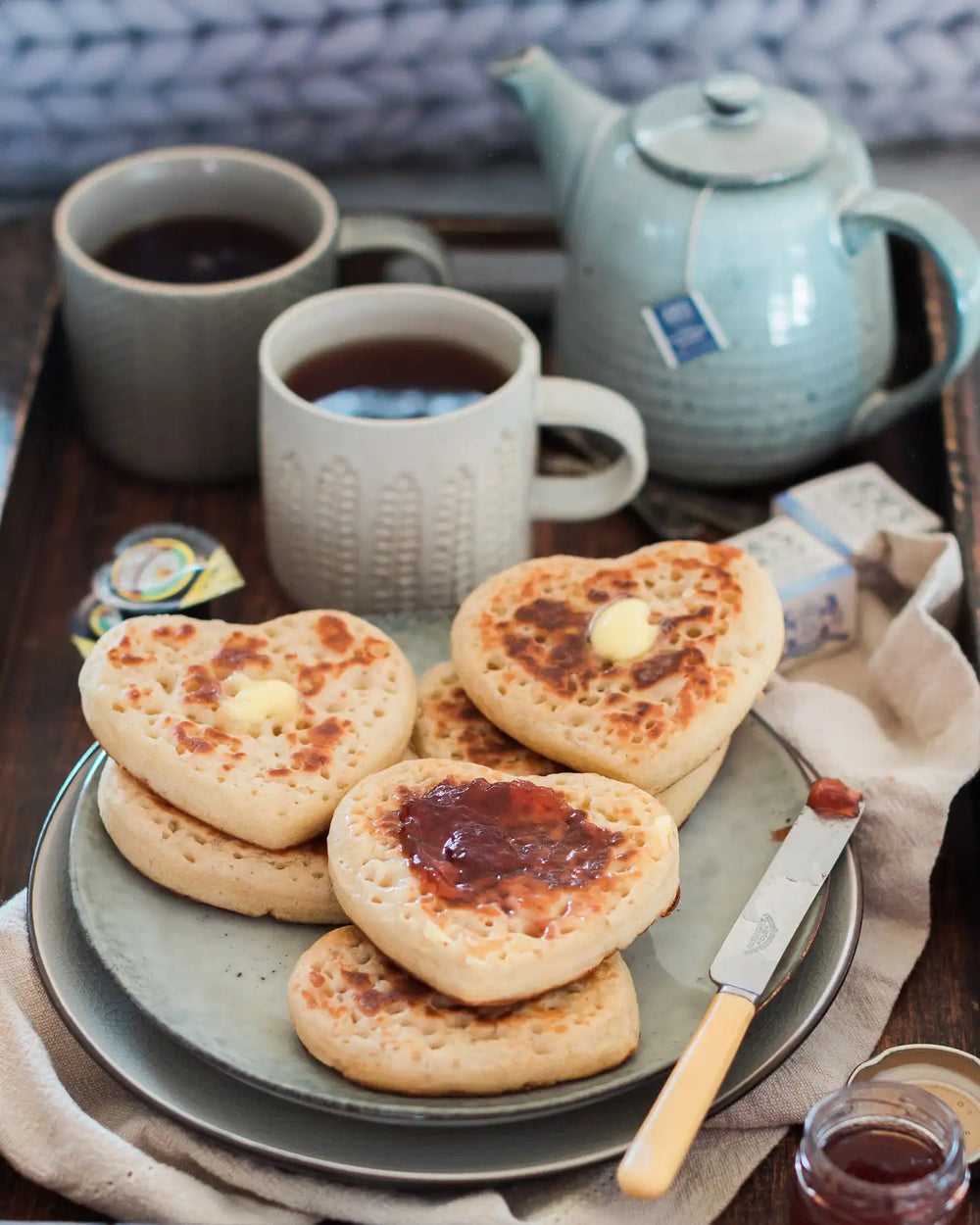 Honeywell Bakes Tea And Crumpets For Two Baking Kit - Heart-shaped crumpets with butter and jam on a plate with mugs of tea and a teapot.