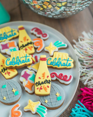 Honeywell Bakes The Celebration Jar - Decorative cookies with celebratory text on a plate, with a disco ball in the background.