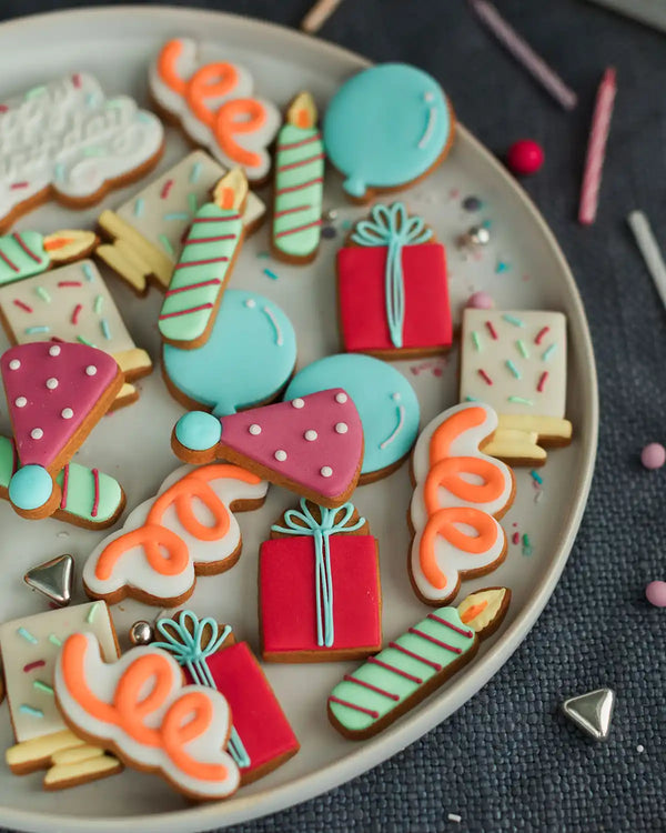 Honeywell Bakes The Happy Birthday Biscuit Jar - Colourful decorated cookies on a plate with a dark textured background
