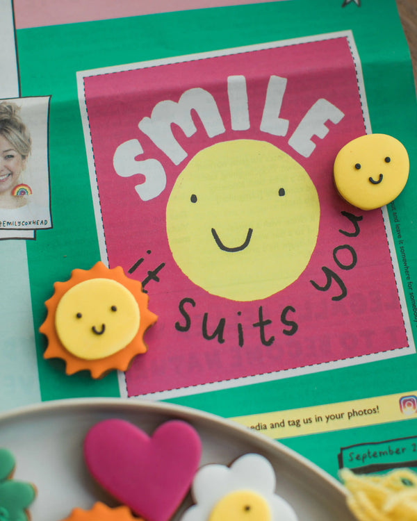 Honeywell Bakes The Happy News Biscuit Jar - Colourful card with a smiley face and text on a green background